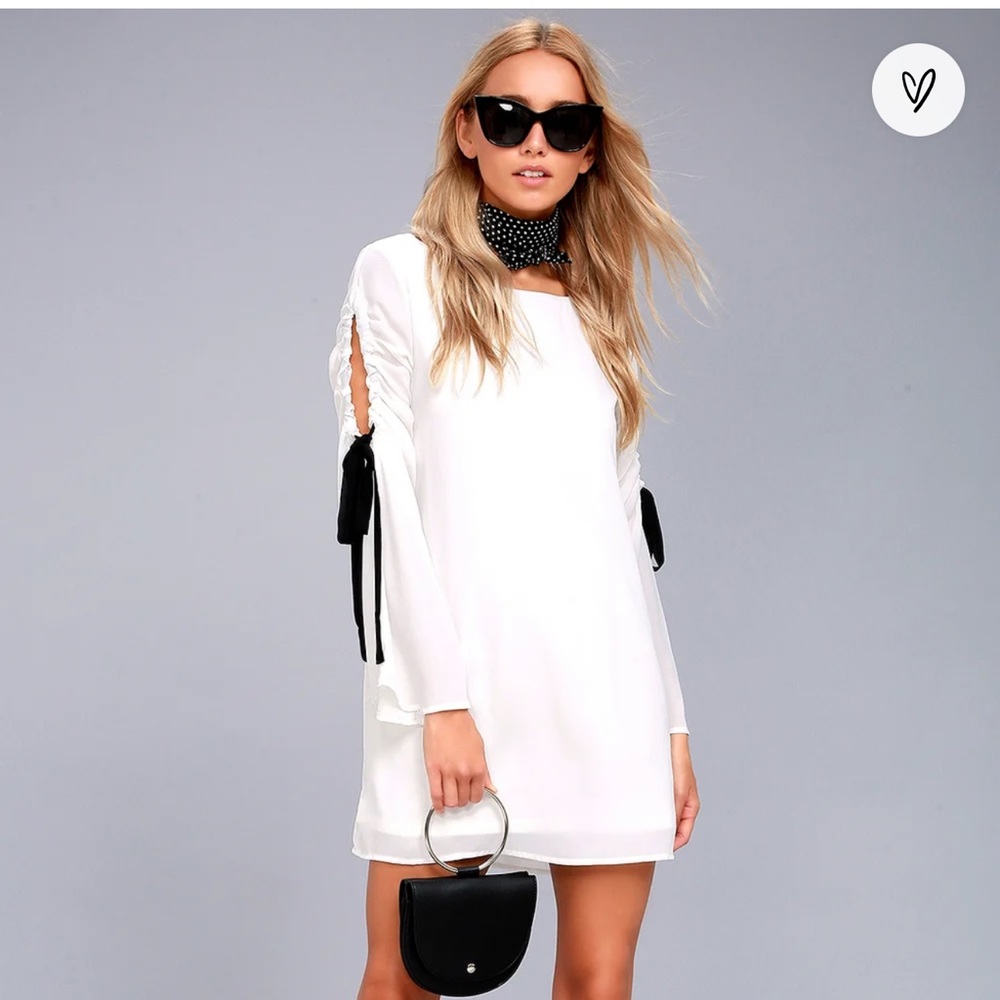 Lulu’s Cherish White Long Sleeve Shift Dress With Black Bow Detail.